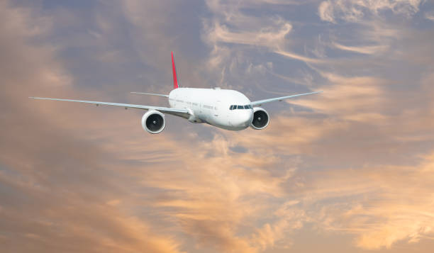 istock Airplane flying over tropical sea at sunset 2189752833