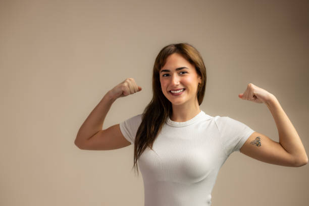 istock beautiful brunette in white t shirt shows muscle 2189753385