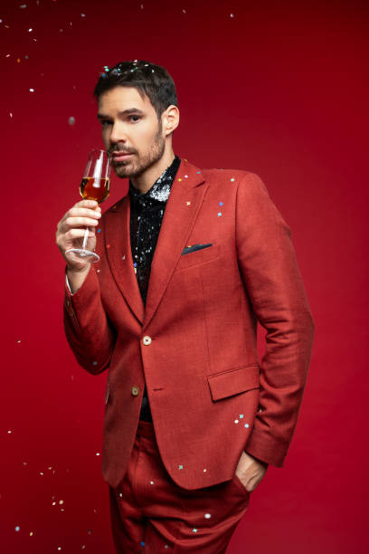 istock Stylish Man in Red Suit Holding Champagne Glass 2189755888
