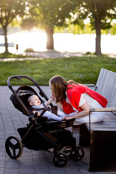 istock Young mother with her cute baby is sitting on a park bench 2189757425