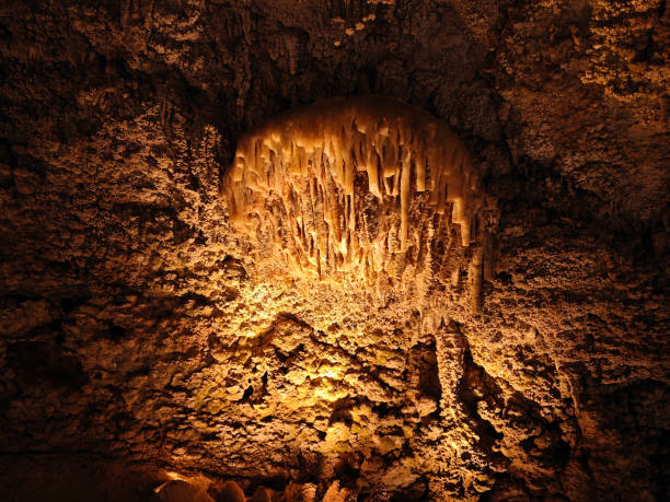 a giant Stalactites stone in the cave with yellow light