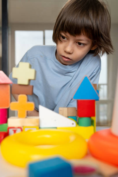 istock Creative child plays with colorful wooden building blocks and trees, showcasing imagination and joy in indoor environment filled with vibrant toys and playful creativity. 2189762621