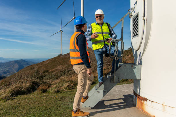 istock Engineers discussing next to a wind turbine on a hilltop 2189762689