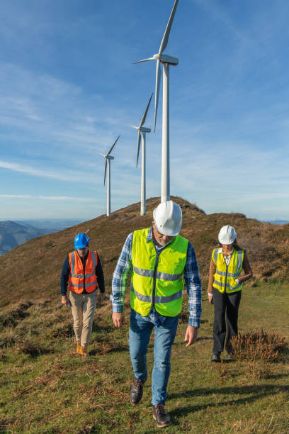 istock Engineers walking near wind turbines on a mountaintop 2189763657