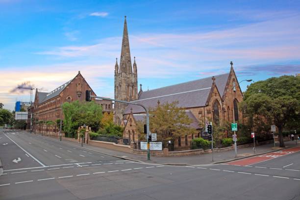 istock Historic church with a tall spire under a vibrant evening sky, framed by trees and quiet streets 2189766538