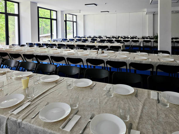 istock Served long table in a large dining room. Cutlery on the table. Wedding table without guests. Hall for ceremonial banquets on the occasion of important events for a large group of people 2189767696