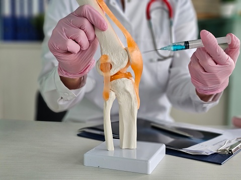Knee Injection Instructions Doctor Explaining Knee Injection Procedure Using Anatomical Model Stock ...