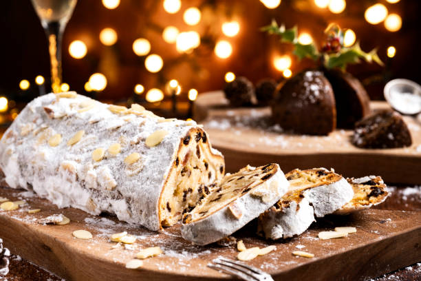 Sliced German Christmas fruit cake known as Stollen cake with bokeh background and Christmas decoration around the fruit cake.