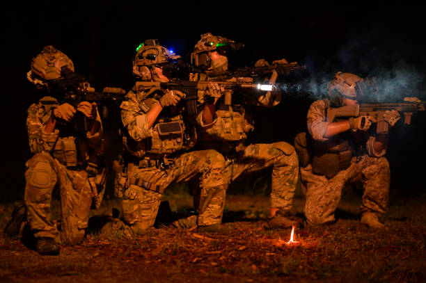 istock Soldiers in camouflage uniforms aiming with their riflesready to fire during Military Operation at night, soldiers training  in a military operation 2189777251