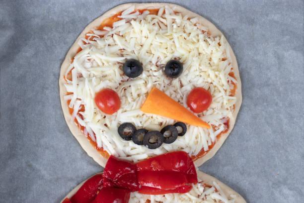 istock Pizza in shape of snowman before baking on baking sheet, preparatory stage, Top view 2189779611