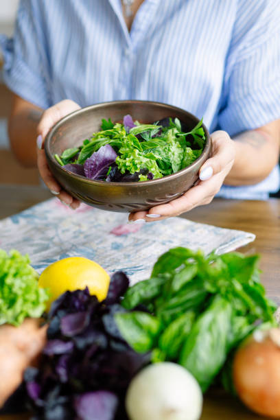 istock Woman hands holds fresh summer salad with greens 2189783227
