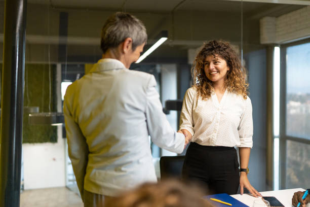 istock Cheerful businesswomen shaking hands in office 2189783558