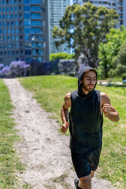 istock Motivated young man sprinting on varying elevations in a park nestled among modern urban designs. 2189783837