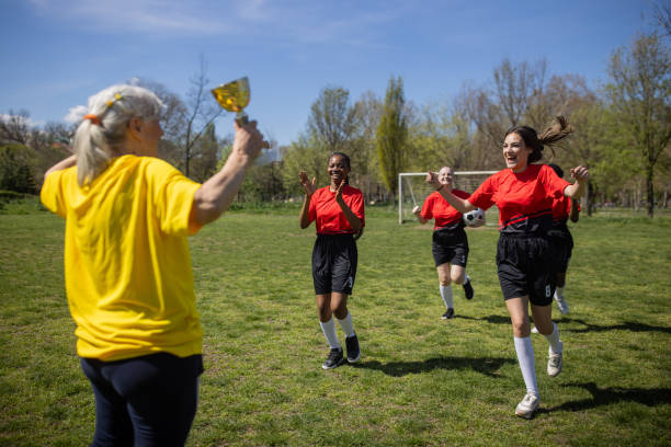 istock Soccer players with coach after they won a trophy 2189787286