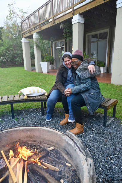 istock Lesbian couple embracing by fire pit 2189790272