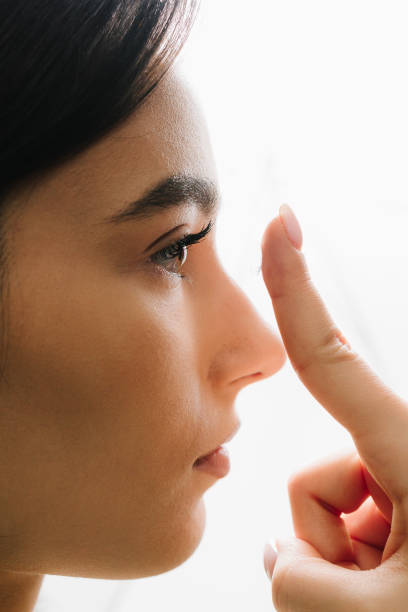 istock Preparing contact lens before use for myopia treatment by woman. Myopia and astigmatism therapy with eye lenses chosen by ophthalmologist. 2189794589