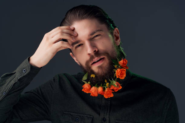bearded man posing flowers in a beard fashion isolated background. High quality photo