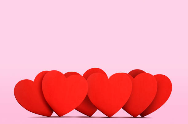 A row of several overlapping heart shapes on a pink background.