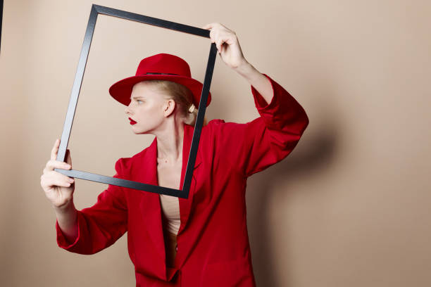 istock pretty woman with wooden frame posing red suit studio model unaltered 2189797632