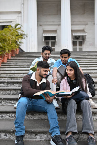 istock Group of University students, studying and discussing sitting on the steps of the campus 2189800007
