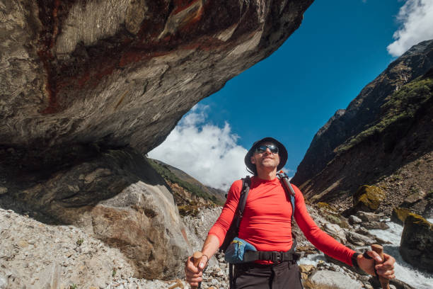 Portrait Young hiker backpacker man in sunglasses smiling in Makalu Barun Park route during high altitude acclimatization walk. Mera peak trekking route, Nepal. Active vacation and sport concept image retrato joven excursionista mochilero hombre con gafas de sol sonriendo en la ruta del parque makalu barun durante la caminata de aclimatación a gran altitud. ruta de trekking por el pico mera, nepal. imagen conceptual de vacaciones activas y deporte