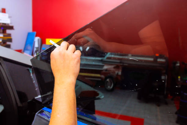 istock Skilled technician applying window tint to a vehicle in an automotive workshop setting 2189813894