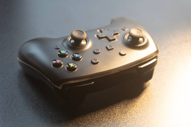 istock A black gaming controller lies on a dark surface, catching soft light, ideal for an evening gaming session 2189816078