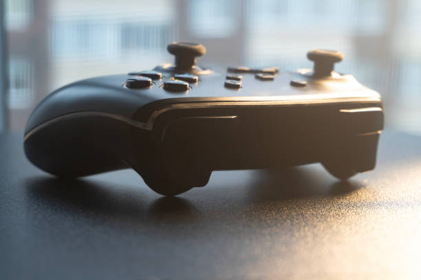 istock A gaming controller sits on a dark surface, softly lit by sunlight coming through a nearby window 2189816081