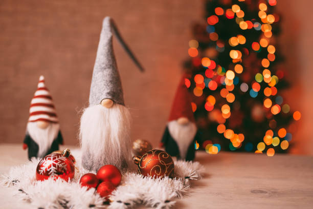 istock Festive Christmas Gnome Decorations with Ornaments and Bokeh Christmas Tree in Background 2189816687