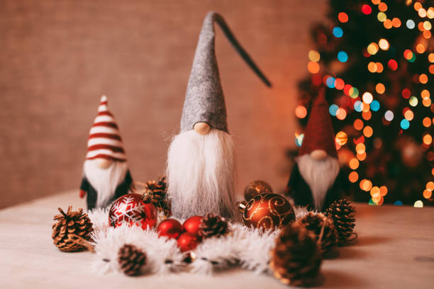 istock Festive Christmas Gnome Decorations with Ornaments and Bokeh Christmas Tree in Background 2189816795