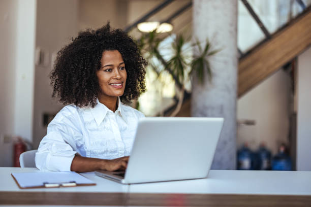 istock Smiling Woman Working on Laptop in Modern Office Setting 2189818169