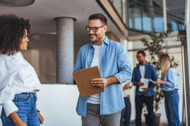 istock Coworkers Engaged in Positive Office Interaction With Laughter and Clipboard 2189818232