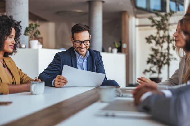 istock Business Team Meeting With Smiling Colleague Holding Document 2189818302