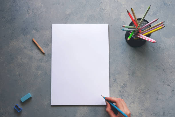 istock Woman writing on a blank white paper on a gray table 2189825276