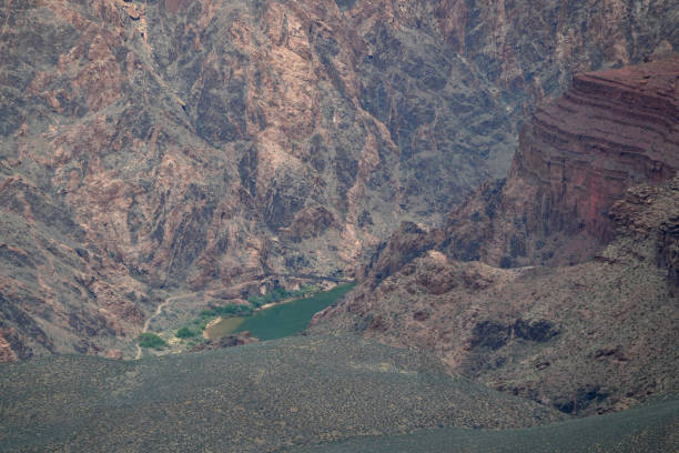 A distant view of the Black Pedestrian Bridge in South Rim at the Grand Canyon, over the turquoise water below it.