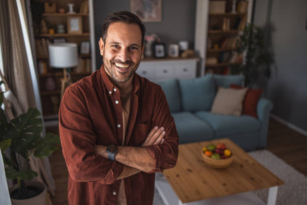 istock Man standing by window in living room 2189827269