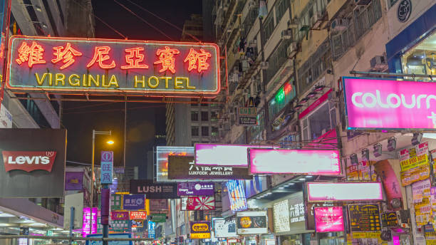 Hong Kong, China - April 30, 2017: Old Style Hanging Neon Sign Virginia Hotel at Mong Kok Kowloon Night Shot With Glow of Manu Commercials.
