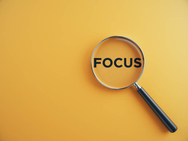 Focus wording inside of Magnifying glass on an orange background