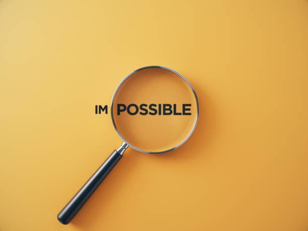 istock Magnifier glass focusing to possible from impossible wording on an orange background. 2189850236