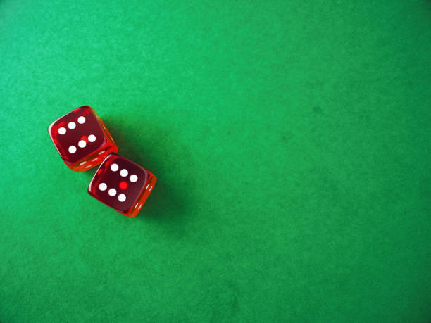 istock Red Transparent Gambling Dice Sitting on Green Fabric Background 2189850466