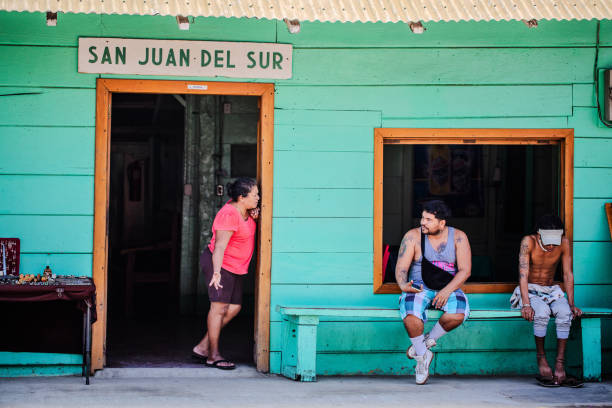 San Juan del Sur, Nicaragua - August 28, 2024. People sitting and conversing outside a building in town.