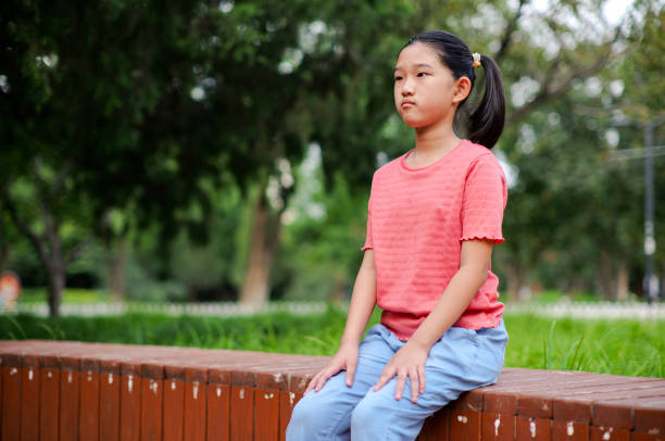 istock Little girl sitting on the bench 2189856967