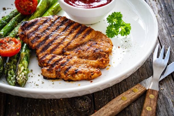 istock Barbecued meat and asparagus on wooden table 2189873666