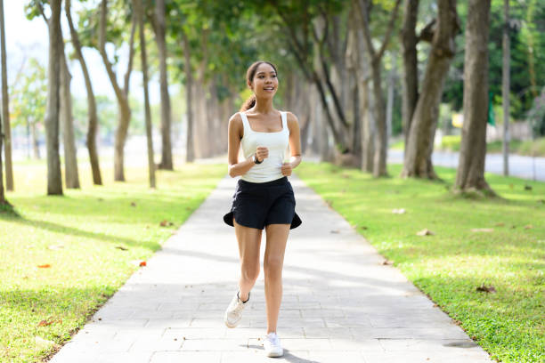 istock Smiling African athletic woman jogging along a pathway in a sunny park 2189877049