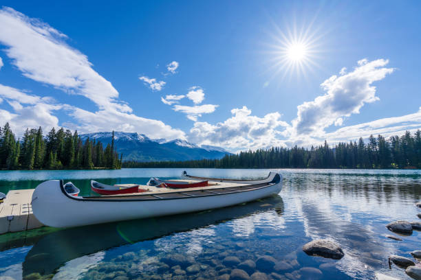 White Canoe on dock at Beauvert Lake (Lac Beauvert). Jasper National Park summer landscape. Alberta, Canada.
