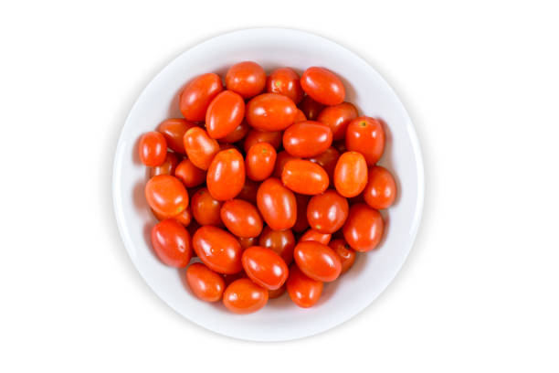 Photo of vibrant fresh grape tomatoes in a classy white bowl isolated on a white background