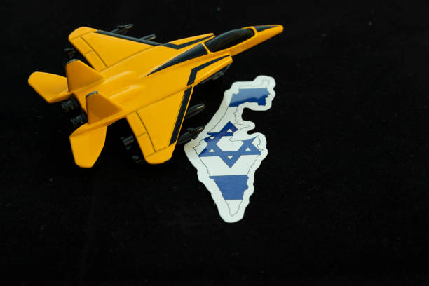 istock A toy fighter jet with Israel map on black background 2189889628