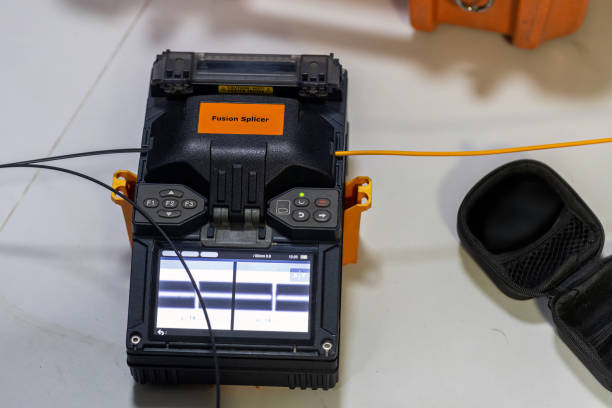 istock Optical fiber installation with Digital Fiber Optical Fusion Splicing machine. High precision fiber optic cleaver is being used during a fiber optic wire install at House. Welding of optical fibers. 2189892694