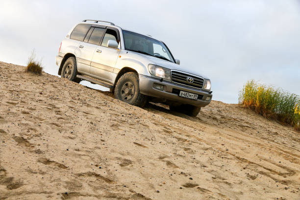 Novyy Urengoy, Russia - July 10, 2021: Grey offroad car Toyota Land Cruiser 100 at the top of the hill.