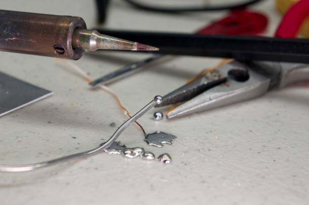 Soldering iron tip with solder and splatter on workbench